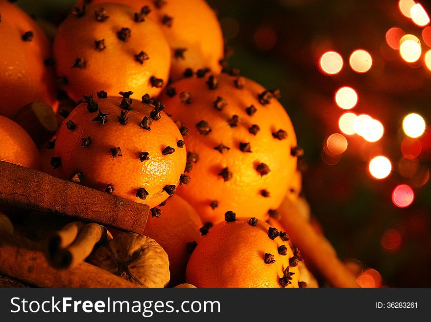 Christmas orange with cloves, fire lights on a background