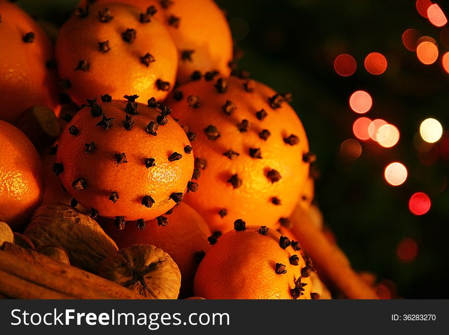 Christmas orange with cloves, fire lights on a background