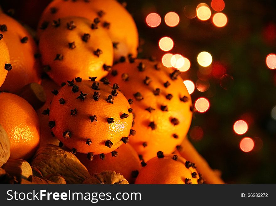 Christmas orange with cloves, fire lights on a background