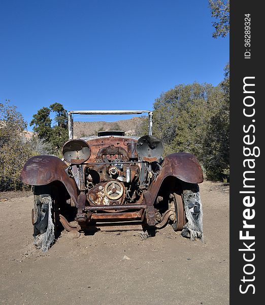 An antique auto sits on the desert floor. An antique auto sits on the desert floor