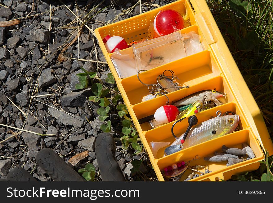 Open yellow fishing box on ground