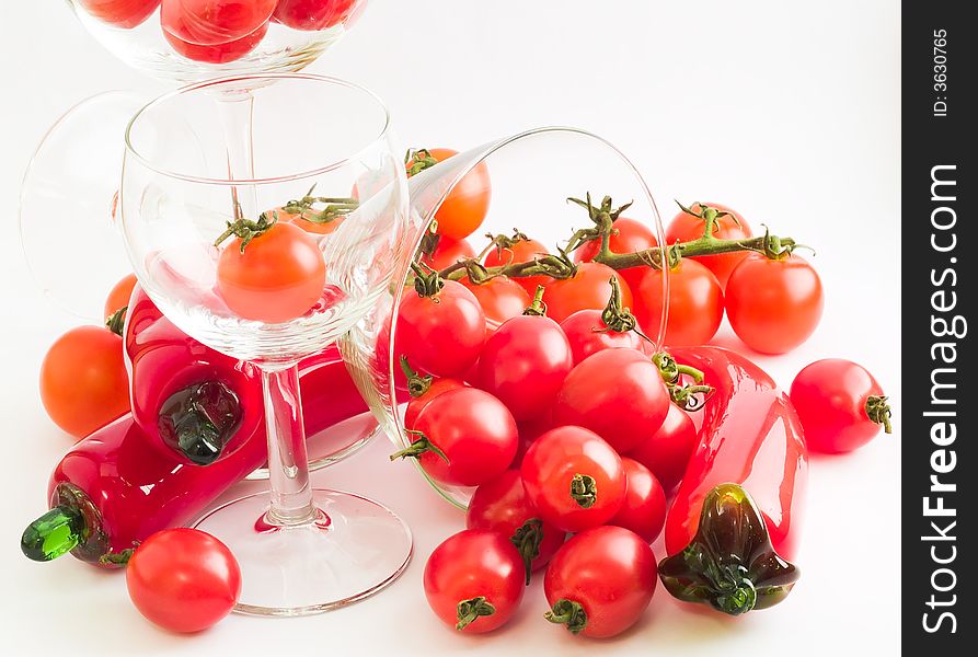 A riot of cherry tomatoes - of two varieties, one on vine - and wine glasses and glass chilies, suggesting salsa, bloody marys, and party and fun. A riot of cherry tomatoes - of two varieties, one on vine - and wine glasses and glass chilies, suggesting salsa, bloody marys, and party and fun.