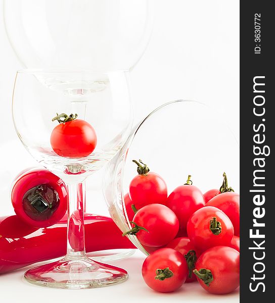 Still life of a riot of cherry tomatoes, wine glasses and glass chilies, suggesting salsa, bloody marys, and party and fun. Still life of a riot of cherry tomatoes, wine glasses and glass chilies, suggesting salsa, bloody marys, and party and fun.