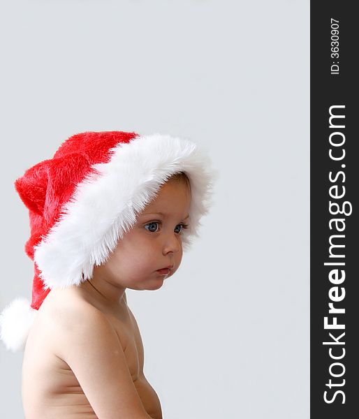 Toddler with a Christmas hat looking tired. Toddler with a Christmas hat looking tired