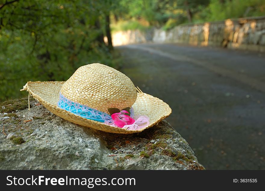 Lost straw hat lay near the road. Lost straw hat lay near the road