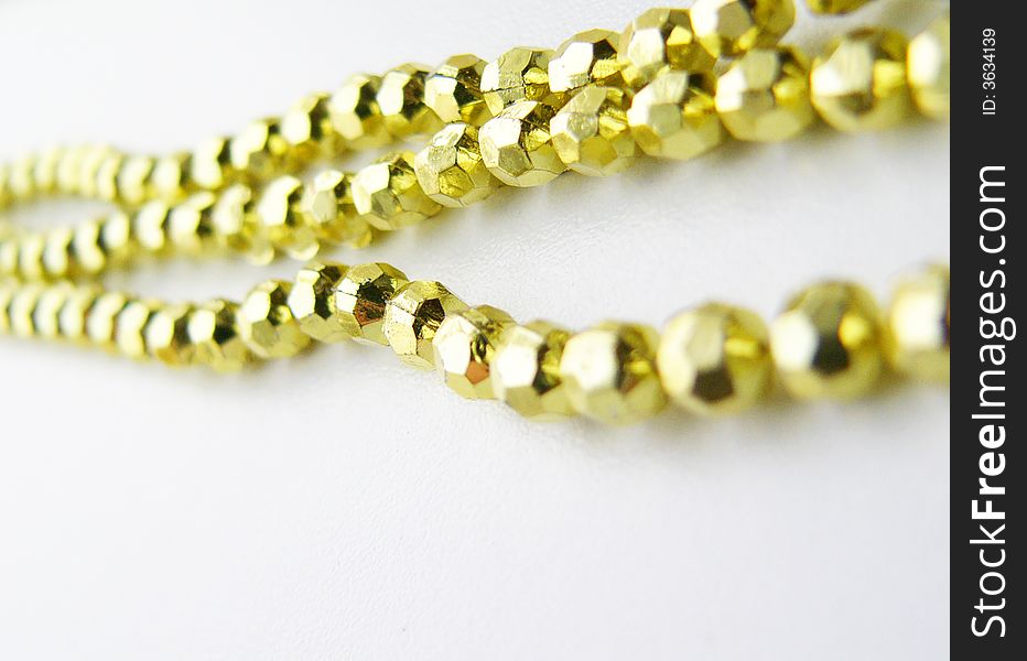Gold beads on a white background