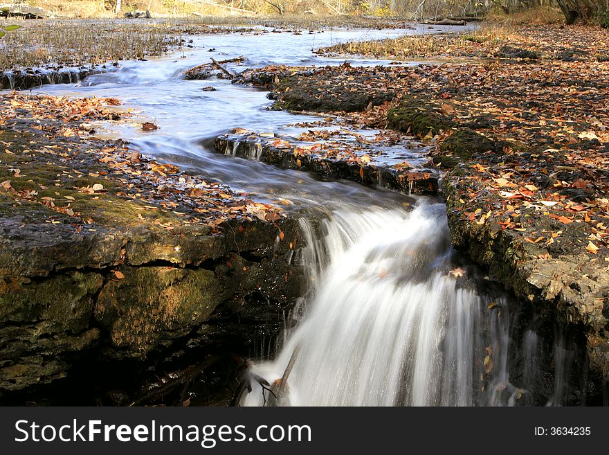 In the late fall , diverse leaves and foliagelight snow help to garnish this beautiful waterfall. In the late fall , diverse leaves and foliagelight snow help to garnish this beautiful waterfall