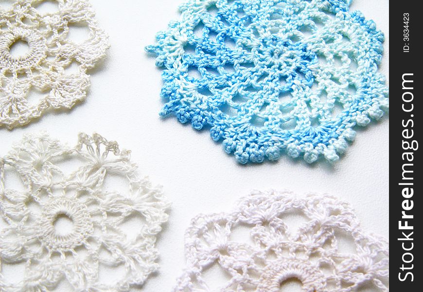 Blue and white snowflakes christmas crochet decorations on a white background. Blue and white snowflakes christmas crochet decorations on a white background