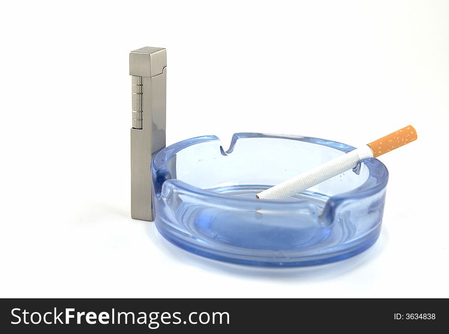 Glass ashtray with a lighter and a cigarette. Glass ashtray with a lighter and a cigarette