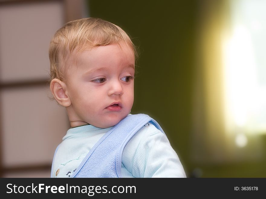 Cute boy looking to the light from the window over his shoulder. Cute boy looking to the light from the window over his shoulder