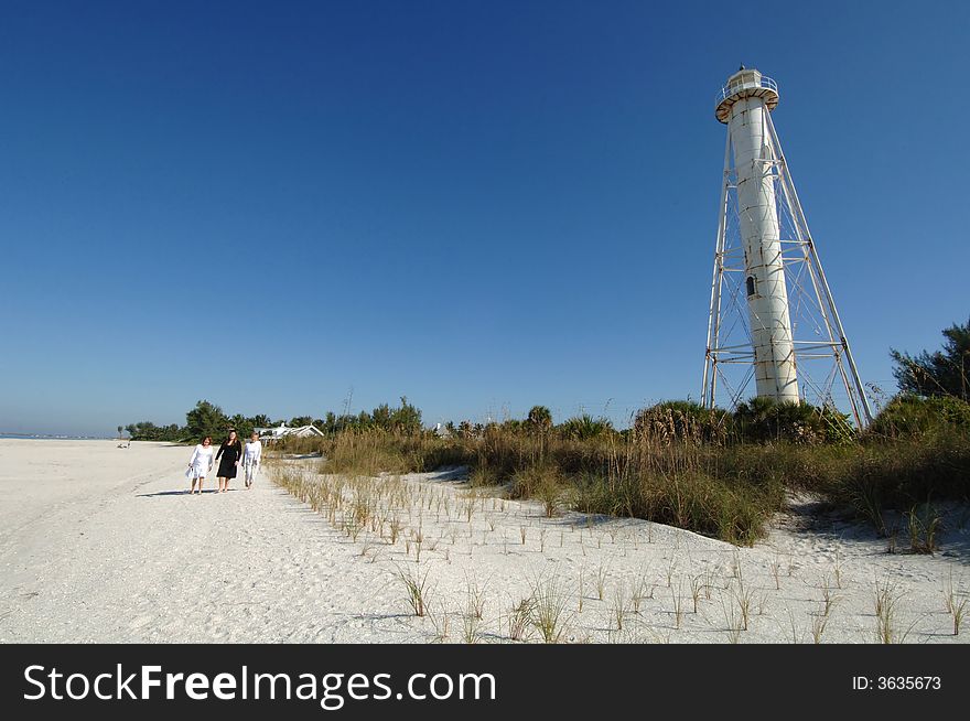 Three women walking along beach near lighthouse in Boca Grande Florida. Three women walking along beach near lighthouse in Boca Grande Florida.