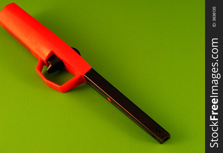 An extended, safety lighter against a green background. An extended, safety lighter against a green background.