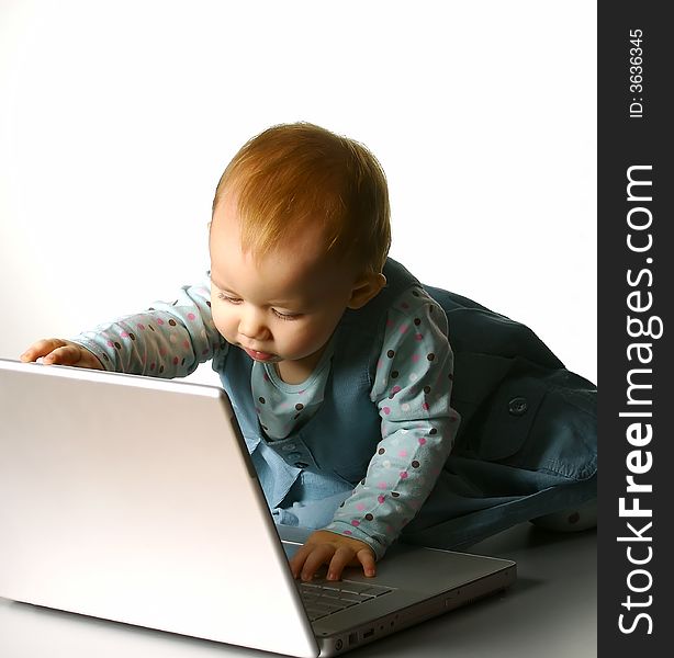 The little girl with a computer on a white background