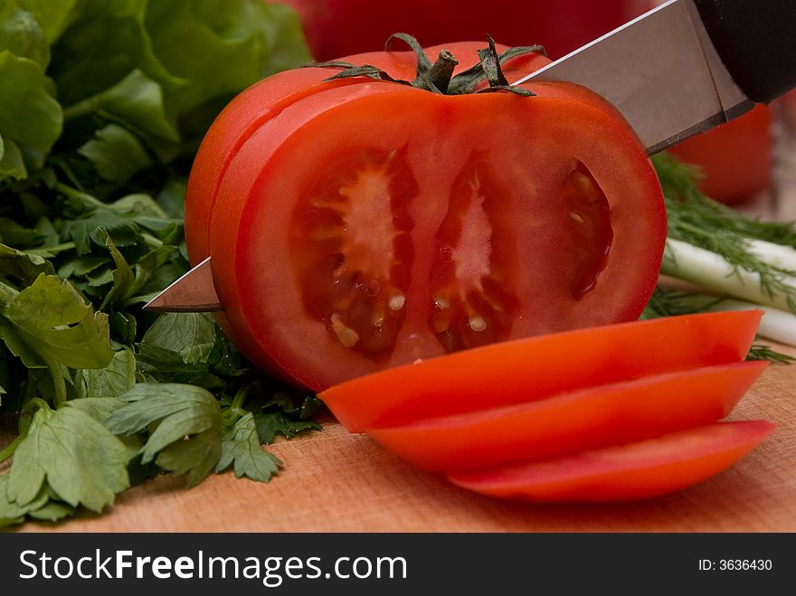 Cutting tomato in slices with knife
