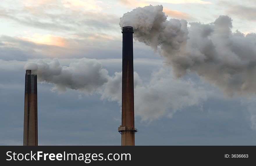 Two smokestacks billowing clouds of fumes adding to global warming. Two smokestacks billowing clouds of fumes adding to global warming