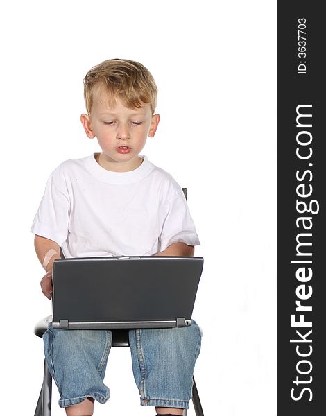 Cute little boy working on a laptop computer. Cute little boy working on a laptop computer