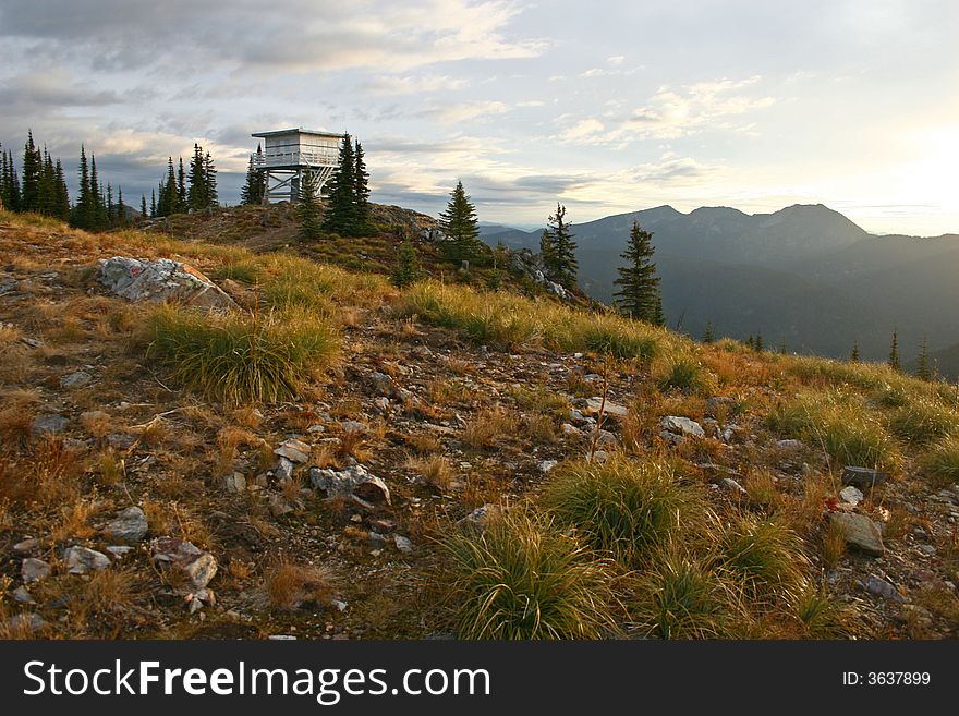 Sunrise over an alpine mountain by a lookout tower. Sunrise over an alpine mountain by a lookout tower.
