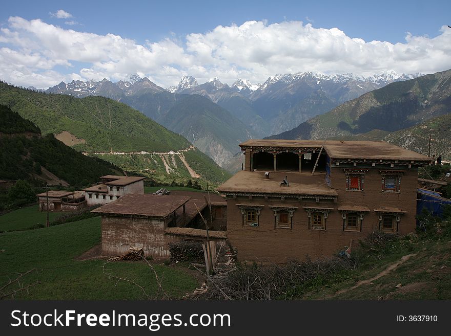 Traditional Tibetan house, with majestic tall mountains in the background. Traditional Tibetan house, with majestic tall mountains in the background