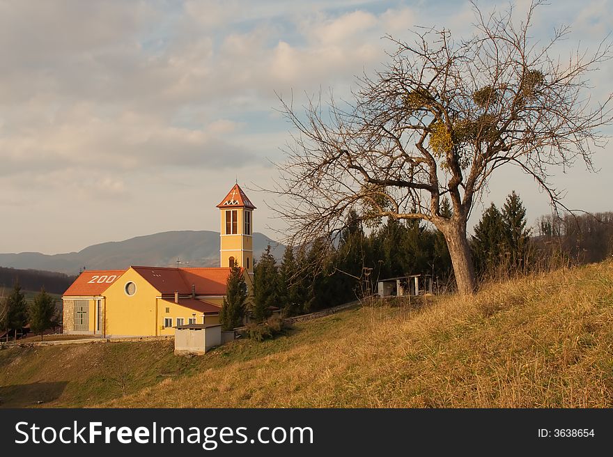 Church with tree and cloudy sky