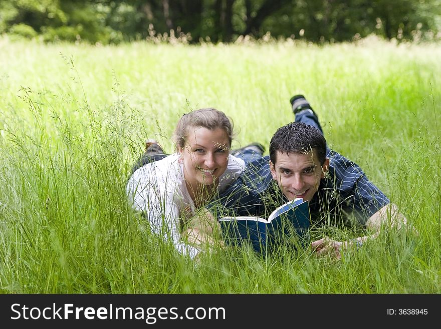Couple on big green grass with book. Couple on big green grass with book