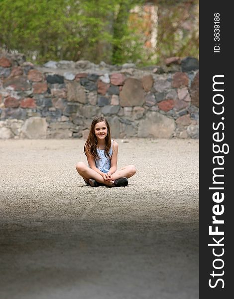 Girl sitting cross-legged on the sand