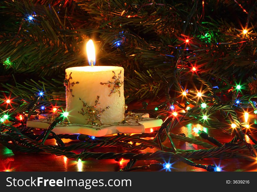 The christmas candle burns on a background with sparks