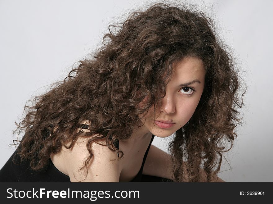 Portrait of a beautiful young brunette woman with curly hair