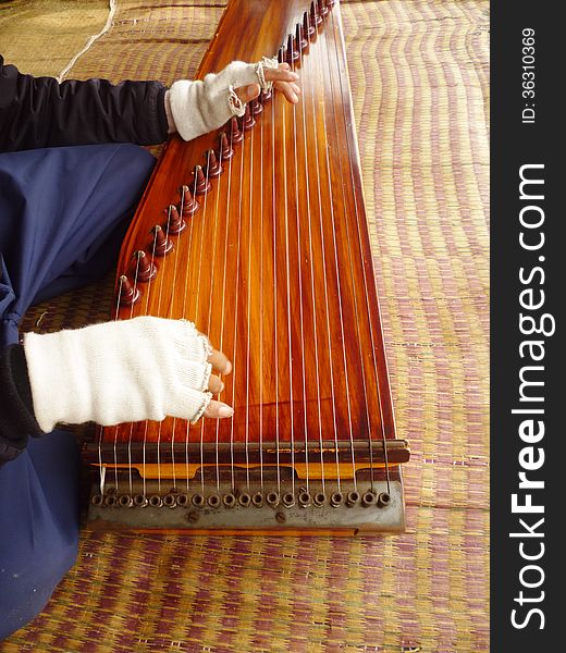 An elderly man playing a harp on a white crater area,