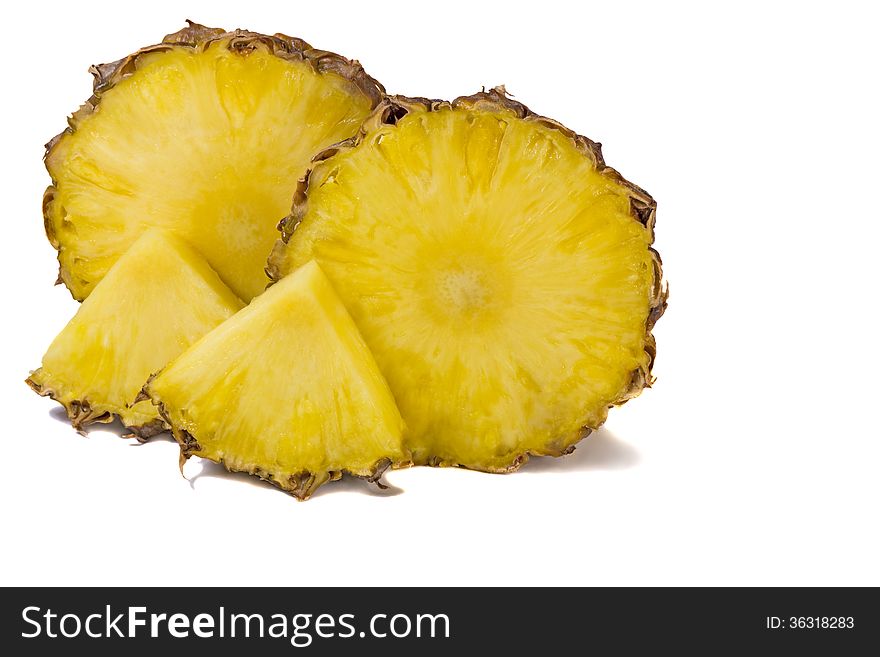 Two large slices of pineapple and two small slices. Presented on a white background. Two large slices of pineapple and two small slices. Presented on a white background.