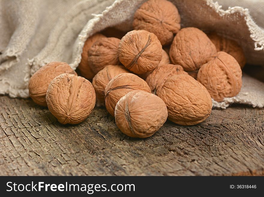 Walnuts in a bag on a wooden surface