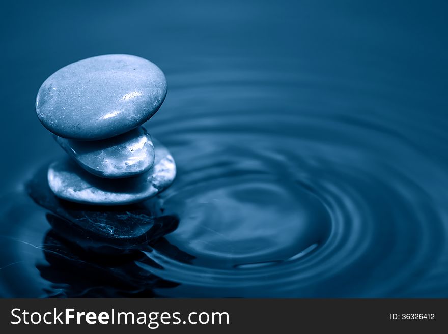 Meditation concept. Stack of stones on dark calm water. Meditation concept. Stack of stones on dark calm water