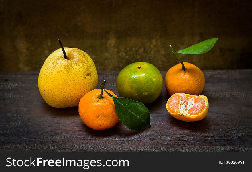 Fresh orange and pear on an old wood table,still life