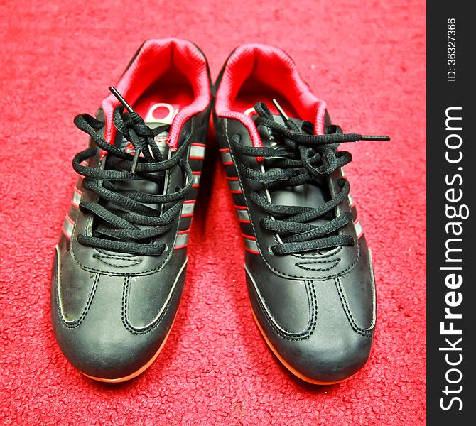 Black sport shoes on red background