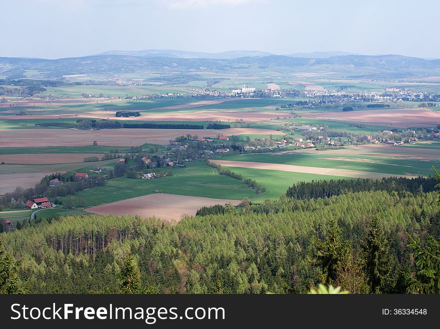 Czech landscape with green and brown field, trees and a village, rural landscape. Czech landscape with green and brown field, trees and a village, rural landscape