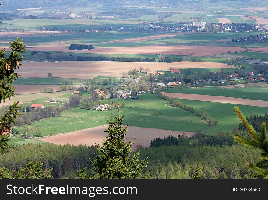 Czech landscape with green and brown field, trees and a village, rural landscape. Czech landscape with green and brown field, trees and a village, rural landscape