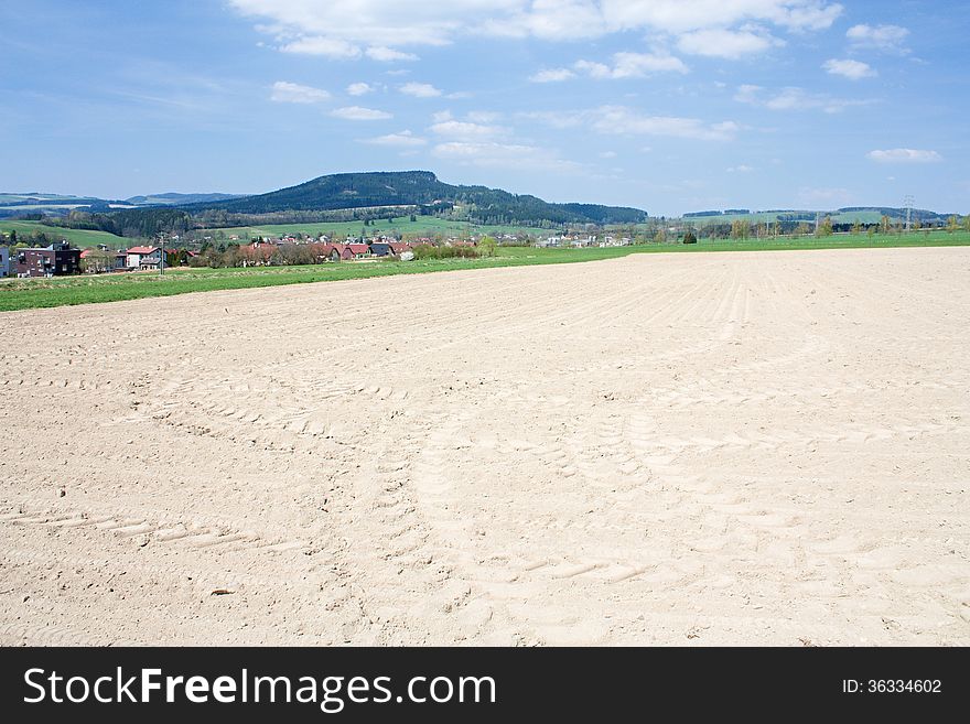 Dry plowed field with tractor tracks from