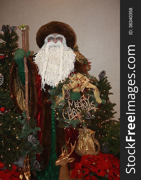 A statue of father Christmas surrounded by other holiday decorations. A statue of father Christmas surrounded by other holiday decorations.