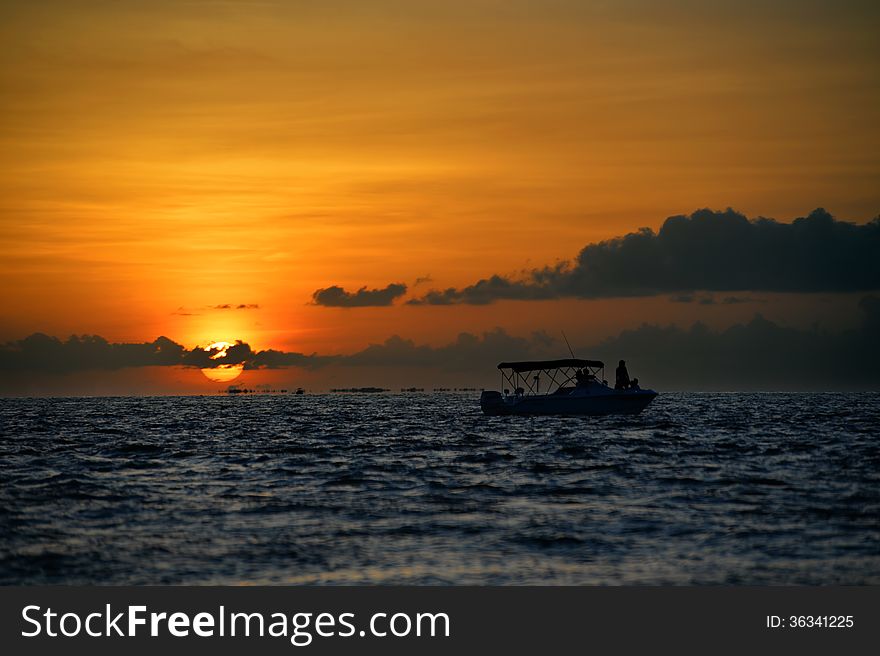 Famous sunset at Key West, FL with boat silhouette against the sun