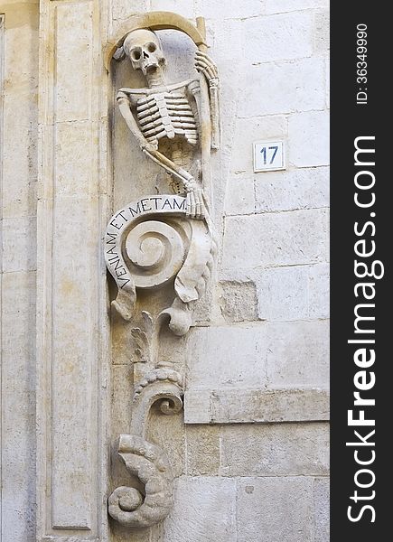 Decoration of the prospectus church Santa Maria del Suffrage Purgatory - Bitonto (Italy). The skeleton carries a scroll, which complements the concept related to the death with the inscription 'We come METAM ET'. Decoration of the prospectus church Santa Maria del Suffrage Purgatory - Bitonto (Italy). The skeleton carries a scroll, which complements the concept related to the death with the inscription 'We come METAM ET'