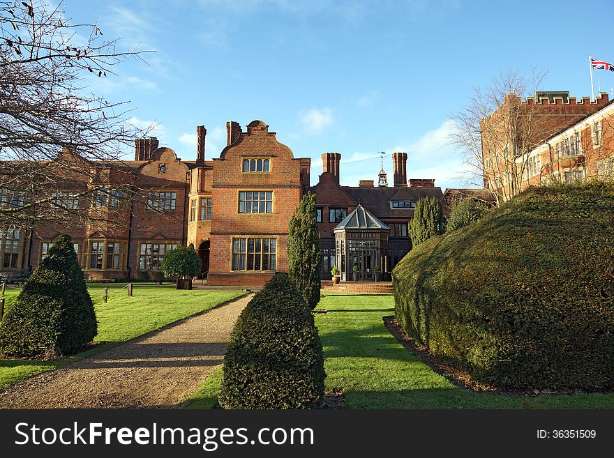 Hanbury Manor Hotel in Ware UK, showing the beautiful garden, trees and pathway out back, a grand building