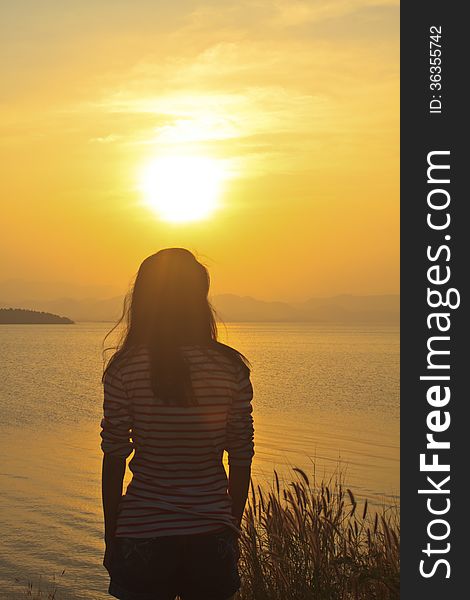 Young girl sitting and have a relax under sunset scene. Young girl sitting and have a relax under sunset scene