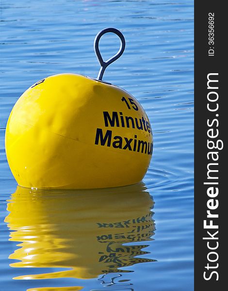 Mooring restriction sign on a yellow buoy floating in blue water at the harbour. Mooring restriction sign on a yellow buoy floating in blue water at the harbour.