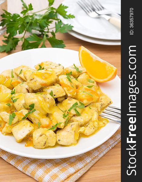 Chicken fillet with orange sauce on a plate, vertical close-up