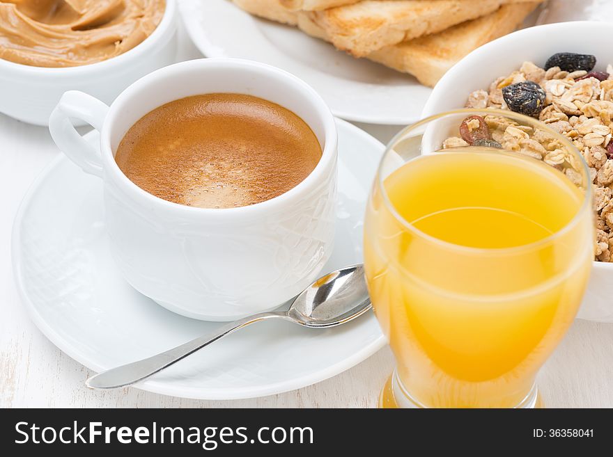 Freshly brewed espresso, orange juice and muesli for breakfast, close-up