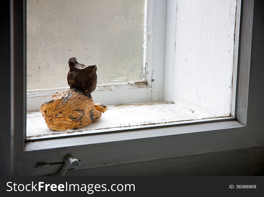 Decorative cat behind a closed window. Decorative cat behind a closed window