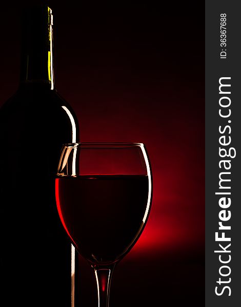 Silhouette of bottle and glass of red wine over dark red background. Silhouette of bottle and glass of red wine over dark red background.