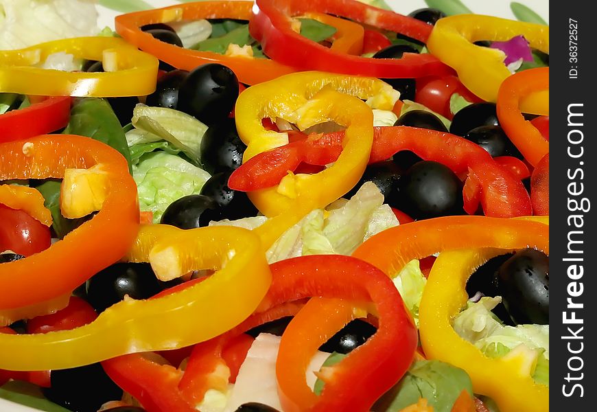 Delicious freshly prepared salad in a decorative Christmas bowl with lettuce, black olives, and different colored bell peppers. Tomato, celerey, onions, radishes, cheese, grated egg were served on the side. Photo taken on Dec 28, 2013. Delicious freshly prepared salad in a decorative Christmas bowl with lettuce, black olives, and different colored bell peppers. Tomato, celerey, onions, radishes, cheese, grated egg were served on the side. Photo taken on Dec 28, 2013.