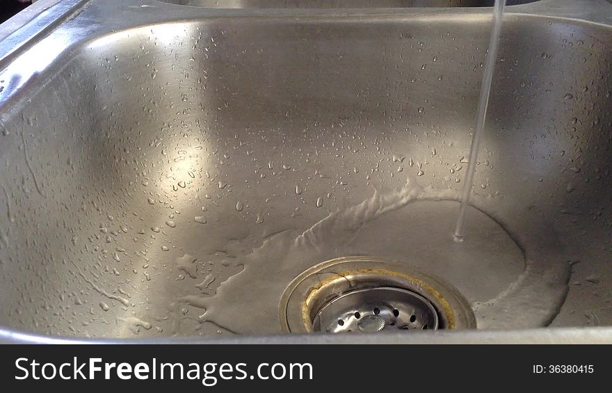 Washing hands with pink soap and running water.