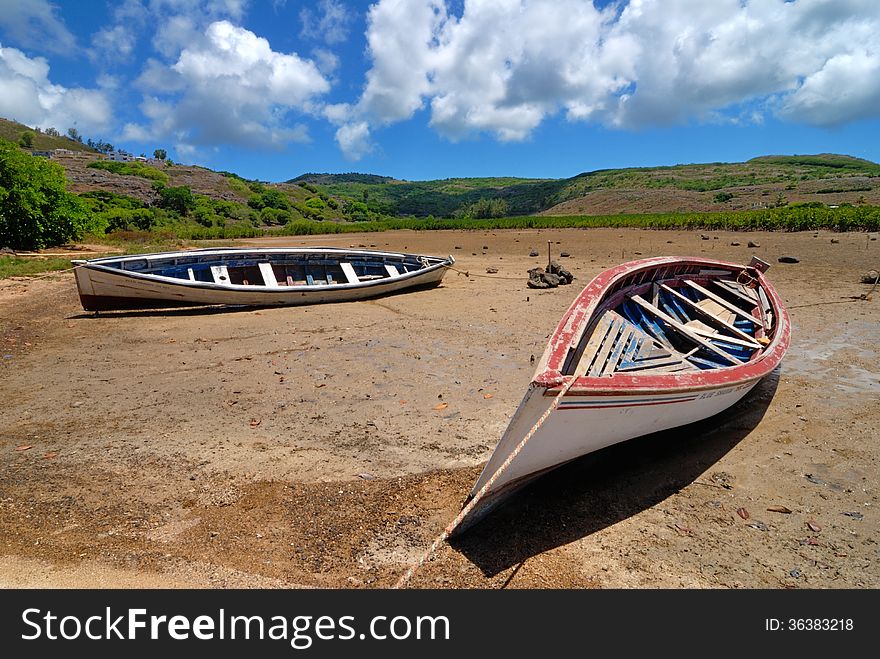 Two fishing boats on dried land at low tide
