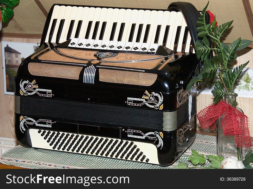 Accordion with a flower in a vase in the living room as a decoration.